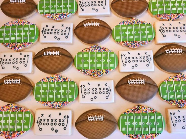 decorated football cookies are arranged on a table