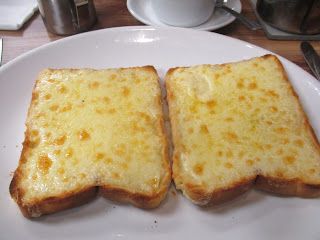 two pieces of cheese toast on a white plate