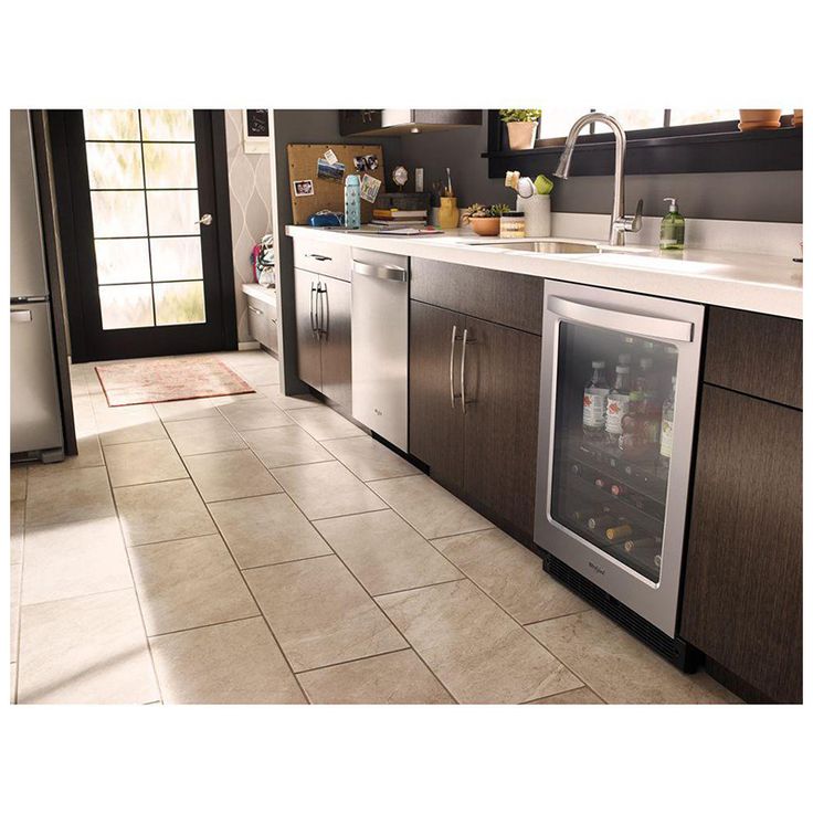 a kitchen with tile flooring and stainless steel appliance, including refrigerators