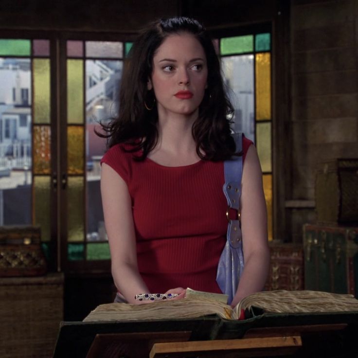 a woman in a red dress is holding an open book