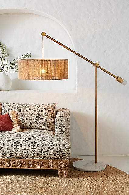 a living room scene with focus on the couch and floor lamp in the corner,