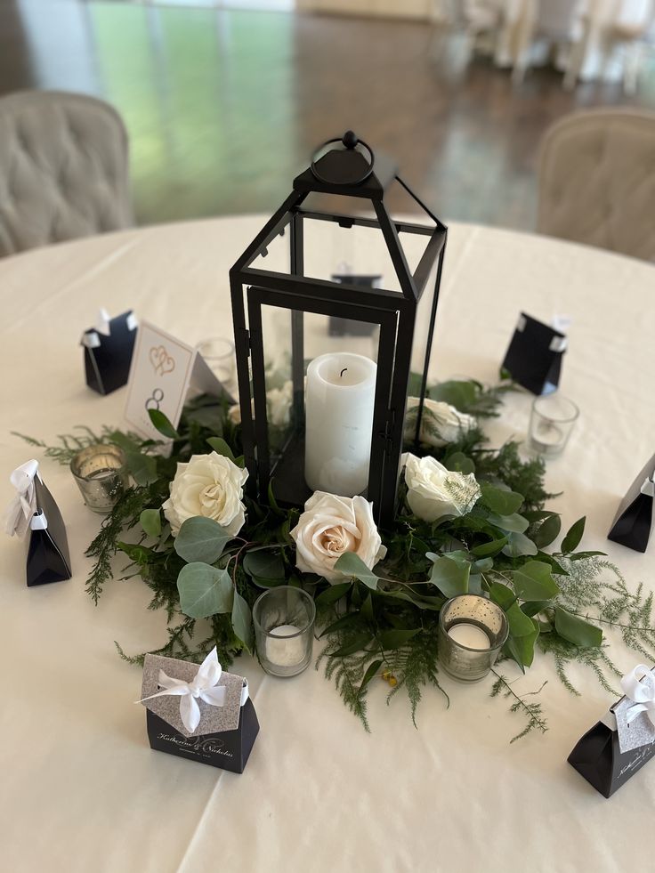 a candle and some flowers on a white table cloth at a wedding or other function