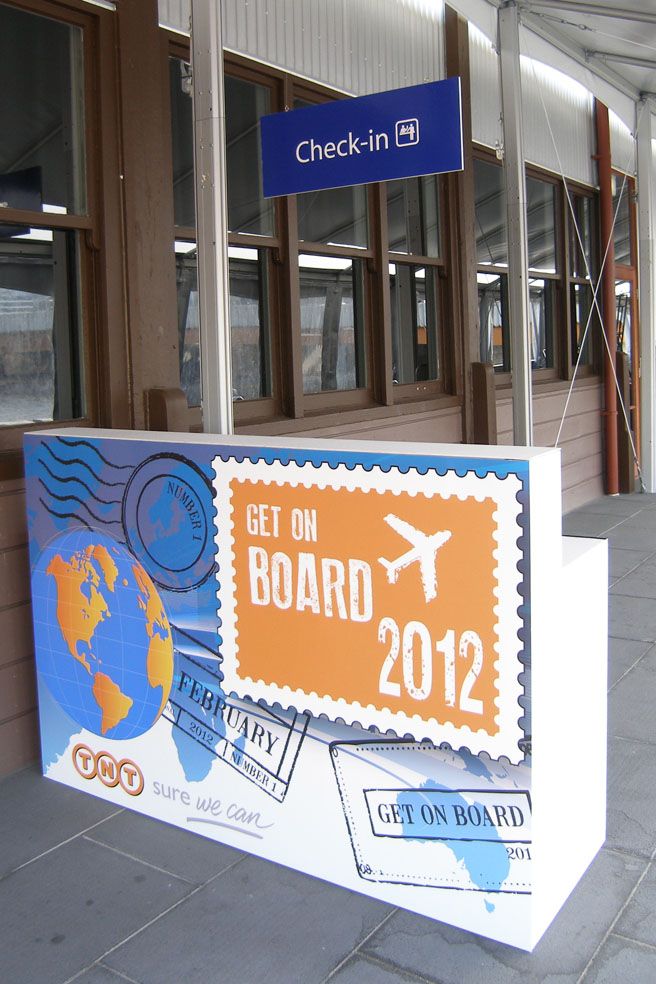 a sign that says get on board 2012 is displayed in front of a building with large windows