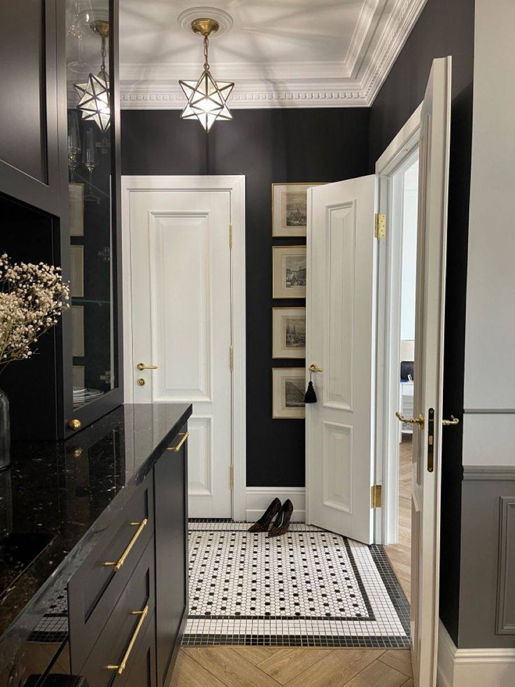 a black and white tiled floor in a room with two doors open to the other side