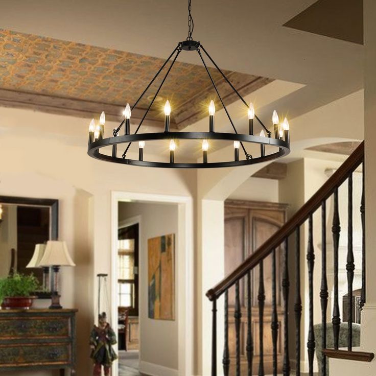 a chandelier hanging from the ceiling in a living room next to a staircase