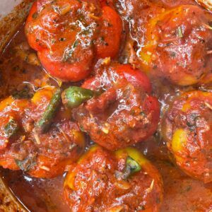 some meatballs and tomatoes are in a pot with tomato sauce on top, ready to be eaten