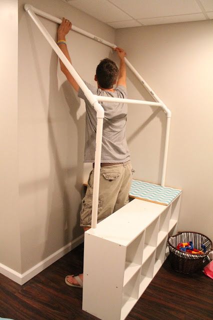 a man standing on top of a white stair case next to a wooden floor and wall