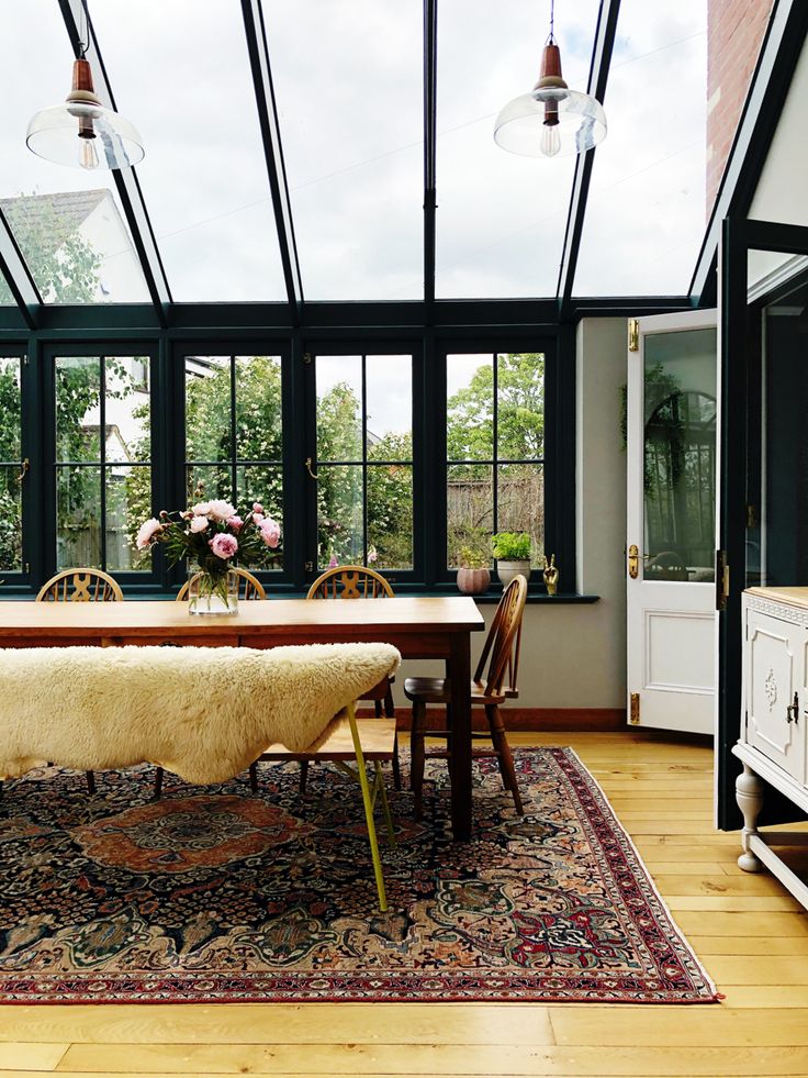 a dining room with large windows and a rug on the floor