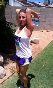 a woman standing on top of a white frisbee in a yard next to a stone wall