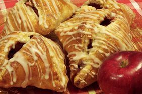 apples and pastries on a red checkered tablecloth