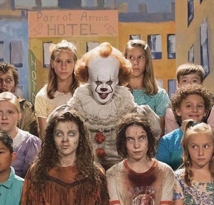 a group of children standing in front of a clown