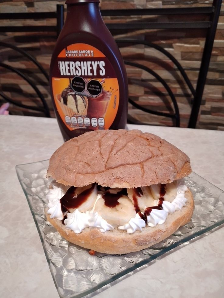 a bottle of hershey's ice cream and a sandwich on a glass plate