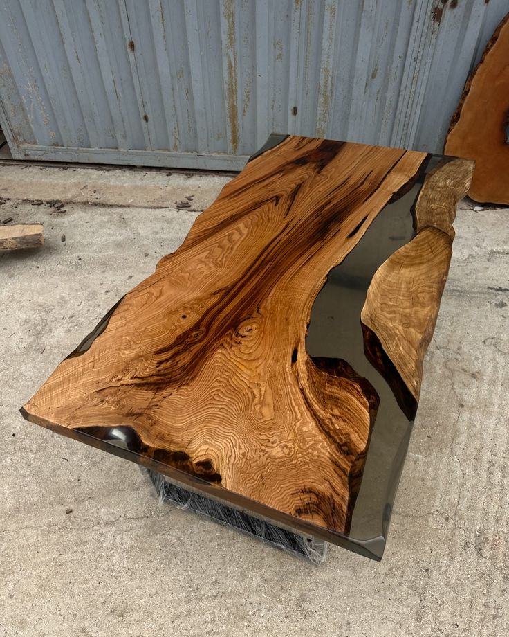 a wooden table sitting on top of a cement floor next to a metal frame and door