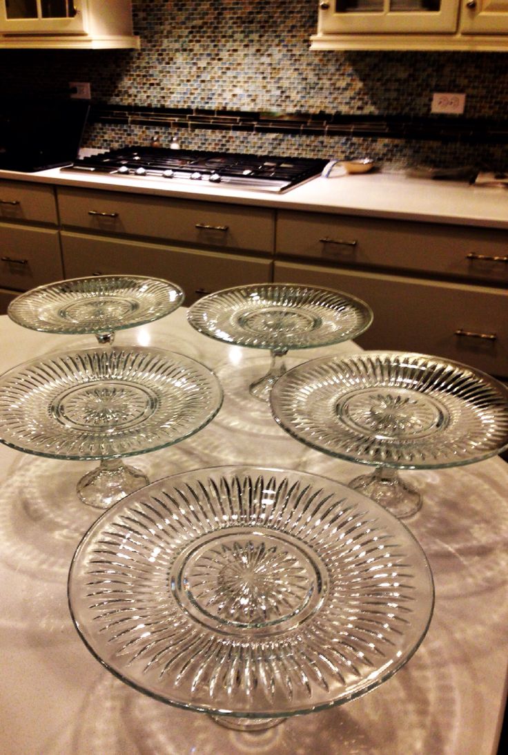 four glass plates sitting on top of a table in front of a stovetop oven