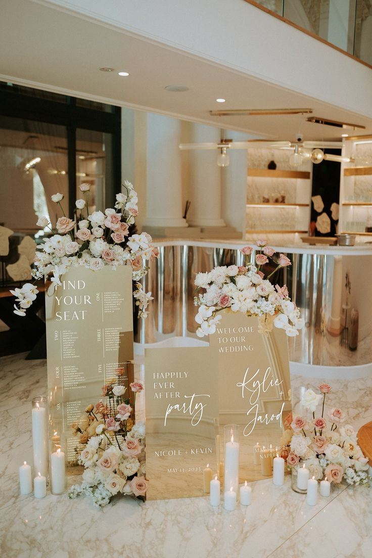 a table with flowers and menus on it next to some candles in front of a staircase