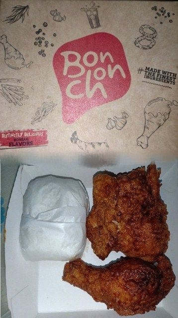 two fried chicken pieces in a box next to a bag of ice cream and a donut