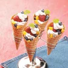 four ice cream cones with fruit on top