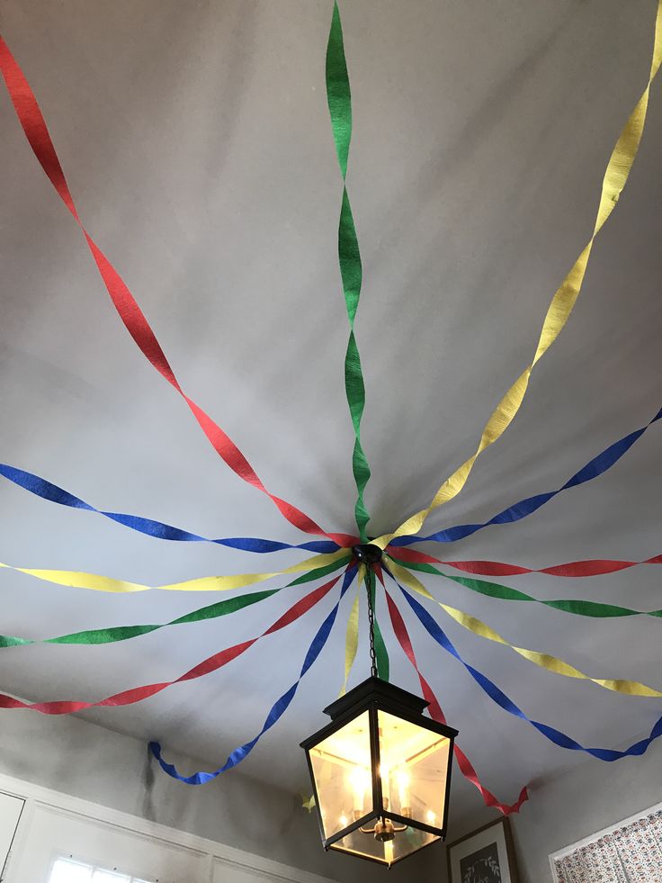 a lamp hanging from the ceiling with streamers on it