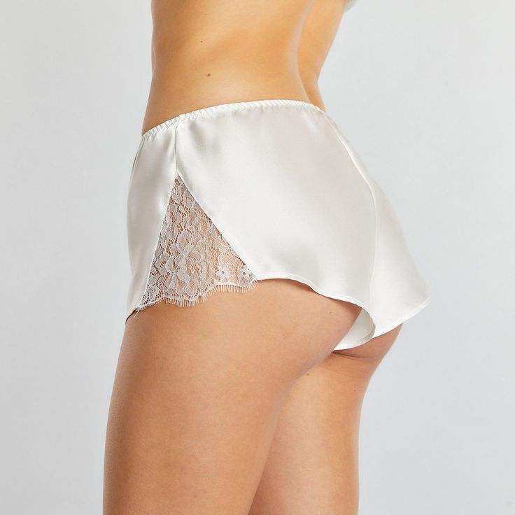 Combine sumptuously soft comfort and exquisitely elegant style with these Charlotte Tap Shorts from Journelle in your lingerie drawer. These tap shorts are made from 100% silk for a soft, lightweight feel that glides over skin while offering comfortable wear. The thigh-length design features a lace panel insert on each side to show off some extra skin, and the daintiest eyelash edging brings even more luxe style to the look for a design that's meant to be shown off. Perfect for pairing with a la Elegant Fitted Shorts For Loungewear, Elegant Brief Bottoms For Loungewear, Elegant Short Bottoms For Daywear, Satin Shorts For Loungewear, Satin Short Bottoms For Loungewear, Satin Lounge Shorts, Satin Loungewear Shorts, Satin Bottoms For Loungewear, Satin Loungewear Bottoms Short Length