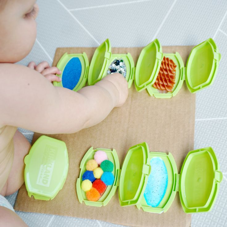 a baby is playing with some green containers