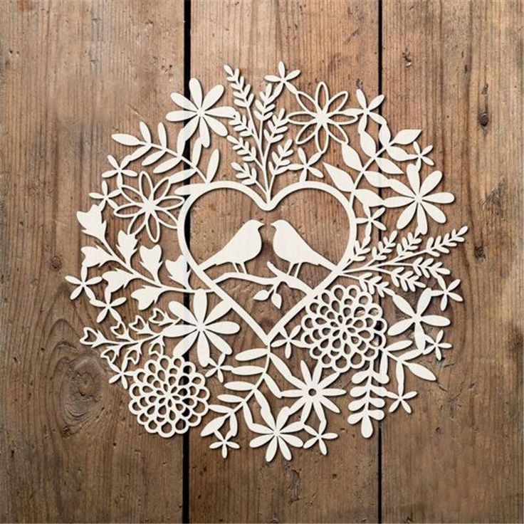 a wooden cutout of a heart surrounded by flowers and birds on a wood background