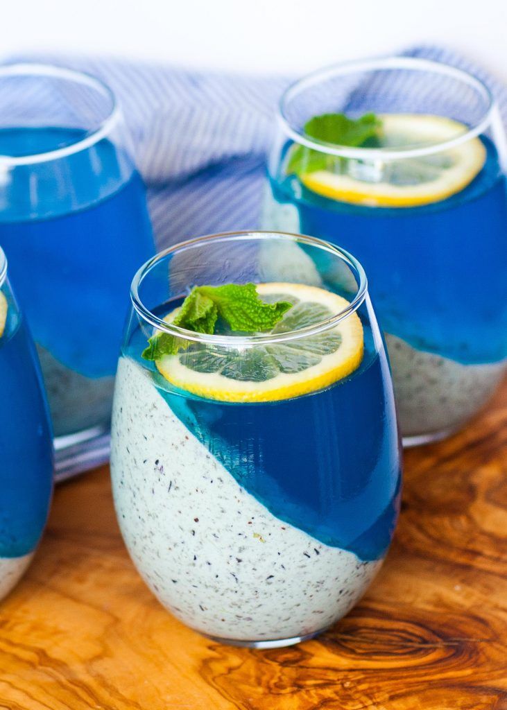 three glasses filled with blue liquid and lemon slices