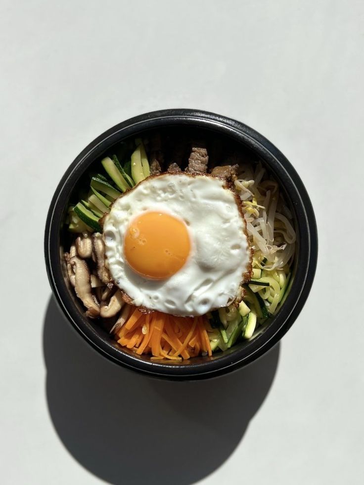 an egg on top of noodles in a bowl