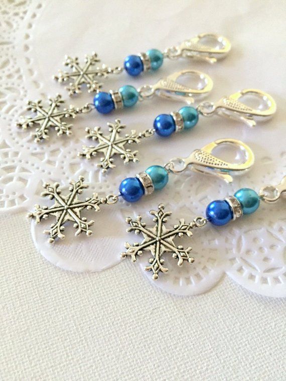 six snowflake earrings with blue beads and silver findings on a lace doily