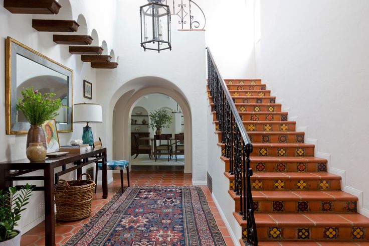 an entryway with stairs and rugs on the floor