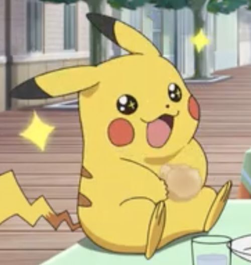 a pikachu sitting on top of a table next to a glass of water