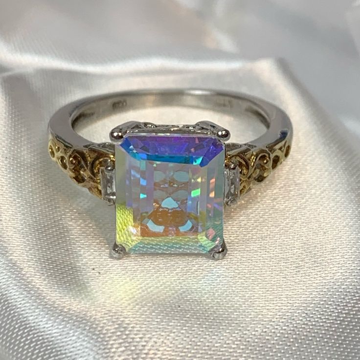 Genuine Mercury Mist Mystic Topaz Ring. 11x9 Octagon, And The Faceted Gemstone Is 5.35 Carats. There Are 2 White Topaz Baguette Stones On Each Side Of The Mystic Topaz. Set In Platinum And 14k Yellow Gold Over .925 Sterling Silver. Size 8. Comes New In Box For Safekeeping And Gift Giving. Nwt Silver Octagon Blue Topaz Ring, Octagon Shaped Silver Topaz Ring, Hallmarked Silver Emerald-cut Gemstones, Silver Octagon Topaz Promise Ring, Octagon Silver Topaz Ring In Sterling Silver, Silver Octagon Topaz Ring Fine Jewelry, Silver Octagon Topaz Ring For Wedding, Silver Octagon Topaz Ring In Fine Jewelry Style, Silver Octagon Emerald Ring For Anniversary