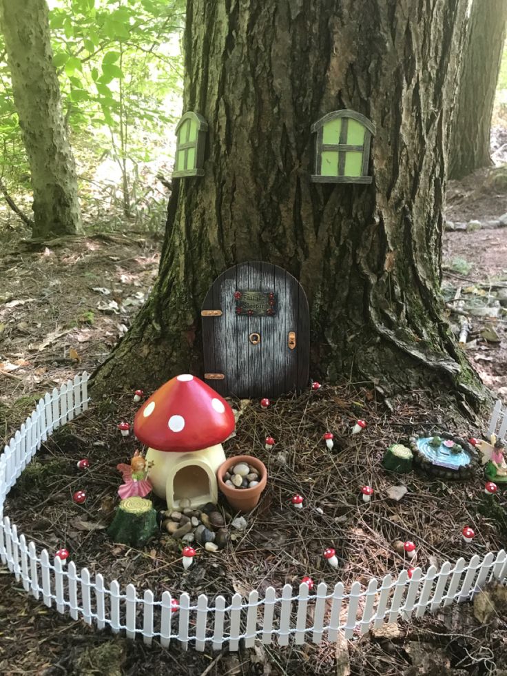 a fairy house in the woods next to a tree