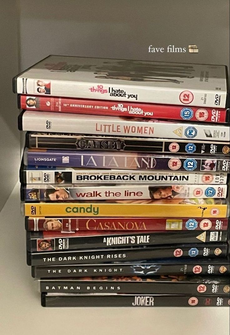 a stack of movies sitting on top of a shelf