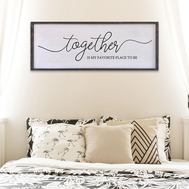 a bed with pillows and a framed sign above it that says together is my favorite place to be