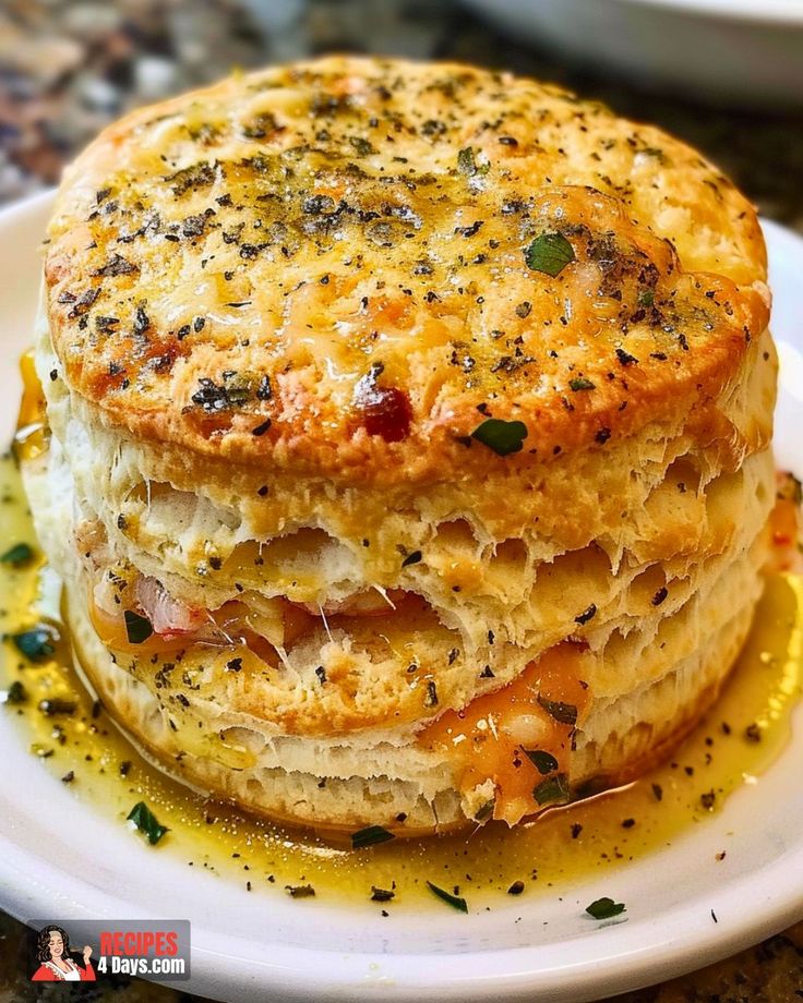 a stack of food sitting on top of a white plate covered in cheese and sauce