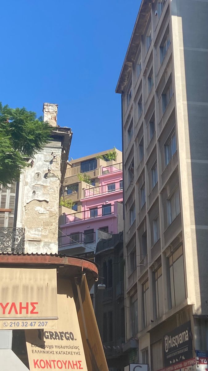 there are many buildings in the city and one is pink, brown, and white