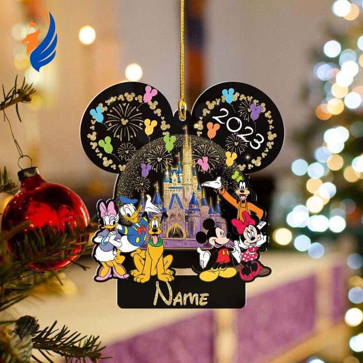 a mickey mouse ornament hanging from a christmas tree with lights in the background