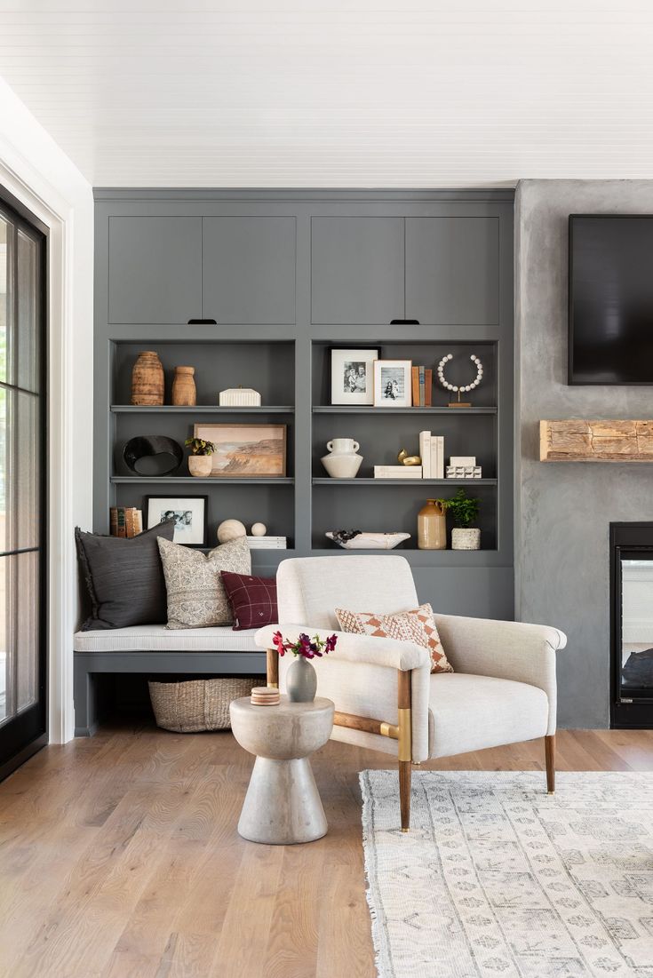 a living room filled with furniture and a flat screen tv mounted on the wall above a fire place