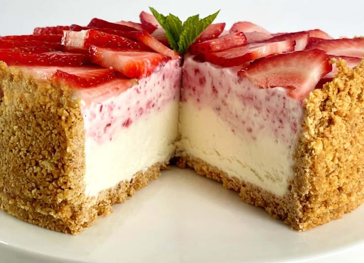 a cheesecake with strawberries is cut in half