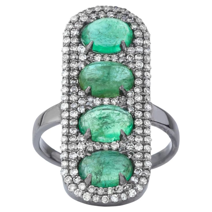 A 9 Carat Diamond and Emerald Cocktail Ring is the epitome of luxury and sophistication. This remarkable piece features a stunning emerald as its centerpiece, exuding an intense, vibrant green hue that captivates the eye. The emerald is expertly cut to enhance its natural brilliance, radiating an alluring depth and richness. Surrounding the central emerald, a halo of dazzling diamonds adds a layer of opulence. Each diamond is carefully chosen for its clarity and cut, ensuring maximum sparkle and light reflection. The halo design accentuates the emerald's vivid color, creating a striking contrast that highlights the beauty of both gemstones. Crafted from the finest precious metals, the ring's band is designed for both elegance and durability. The band features a smooth, polished finish, pro Emerald Cocktail Ring, Emerald Cocktail, Halo Design, Vibrant Green, Light Reflection, Gem Stone, Showcase Design, Cocktail Ring, Cocktail Rings