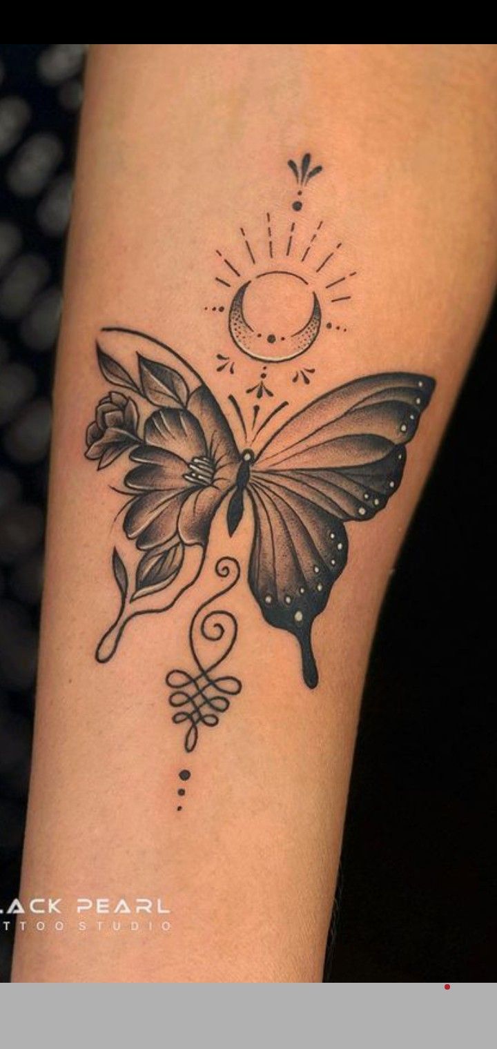 a black and white butterfly tattoo on the arm