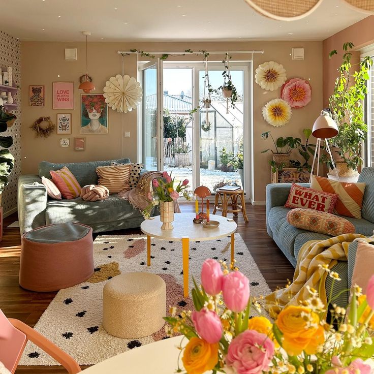 a living room filled with lots of furniture and flowers in vases on the table