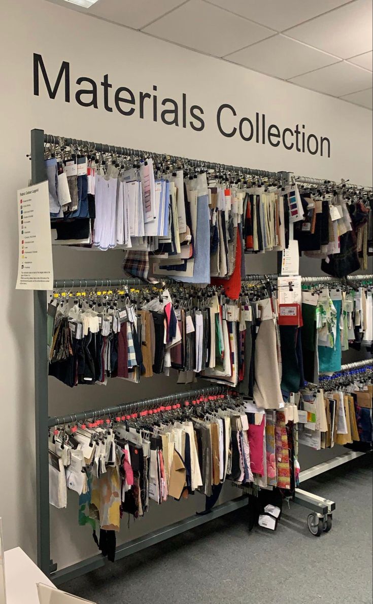 a display case filled with lots of shirts and pants next to a sign that says materials collection