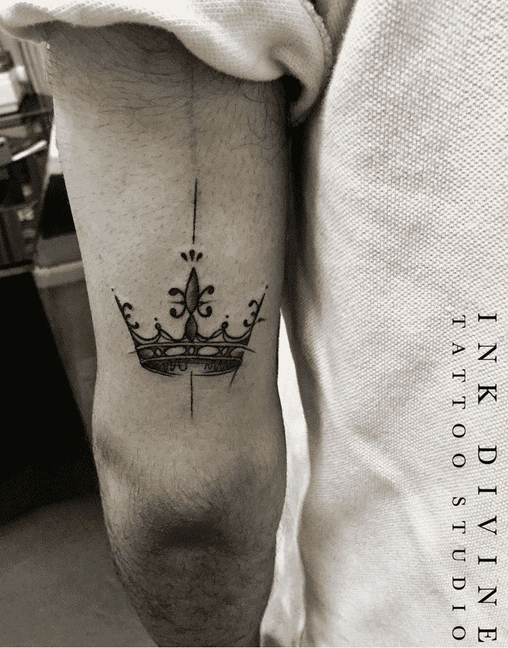 a man with a crown tattoo on his arm