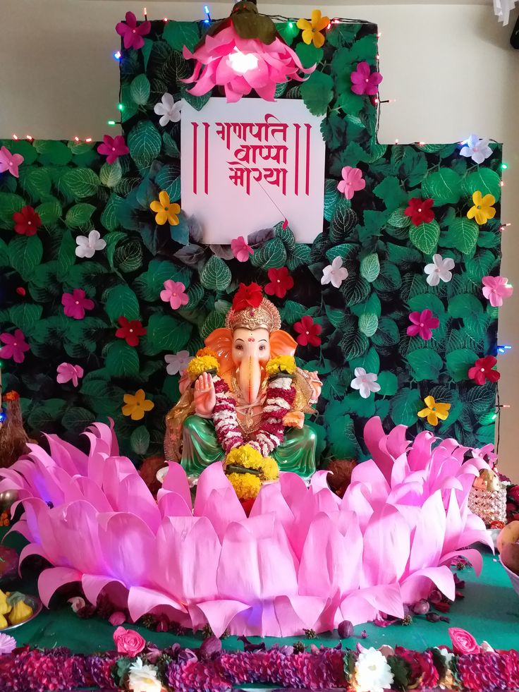 there is a statue of ganesh in the middle of flowers and plants on display