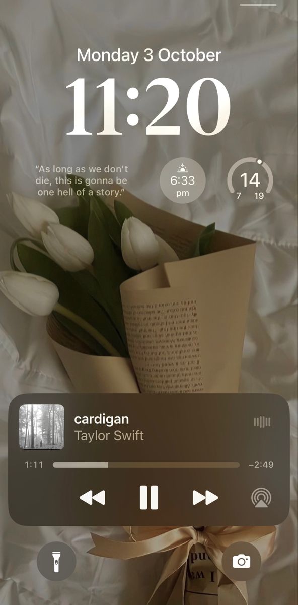 an iphone screen showing the date and time on it, with tulips wrapped in brown paper