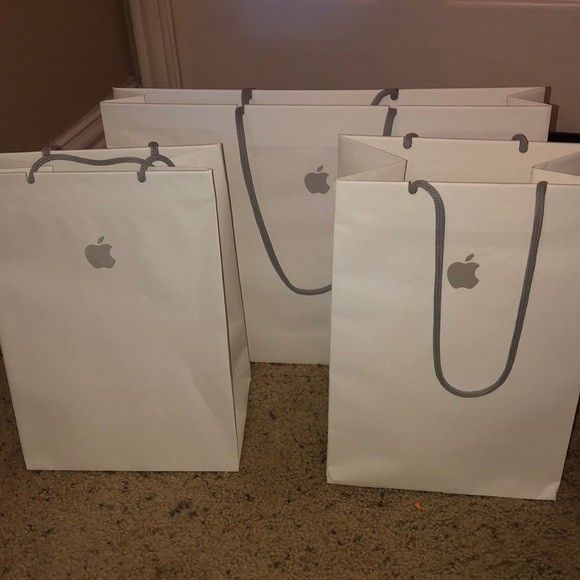 four white bags with apple logos on them