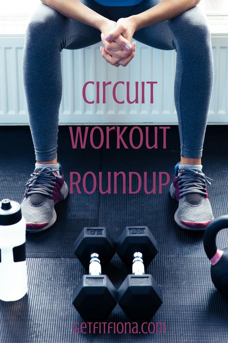 a woman sitting on top of a gym mat with dumbbells in front of her