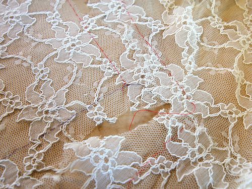 white lace with red thread on fabric