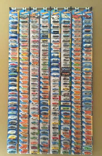 an art piece made out of many different types of toy cars on a white wall